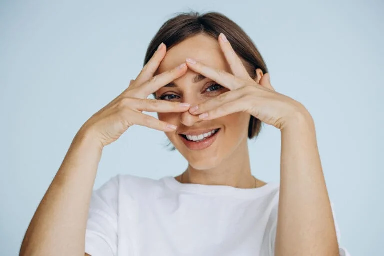Mujer sonriendo realizando ejercicios oculares para aliviar la fatiga visual.